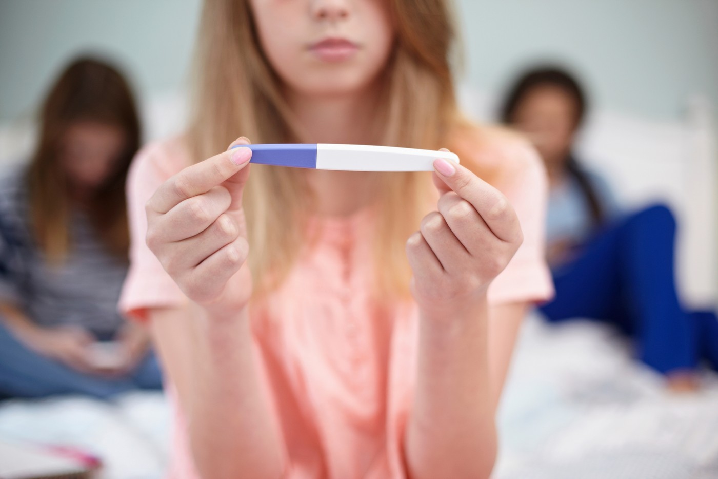 dekle drži v roki test nosečnosti