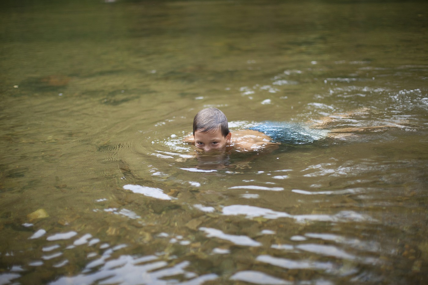 otrok plava v reki