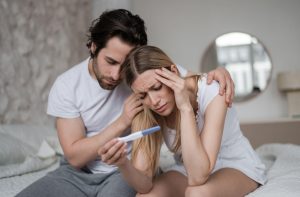 žalostna moški in ženska gledata test nosečnosti
