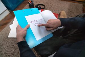 najstnik v sobi z zvezkom začetek šolskega leta