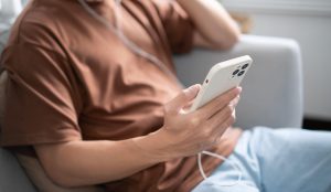 moški na telefonu posluša glasbo