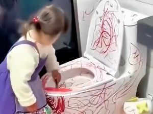 deklica riše po straniščni školjki