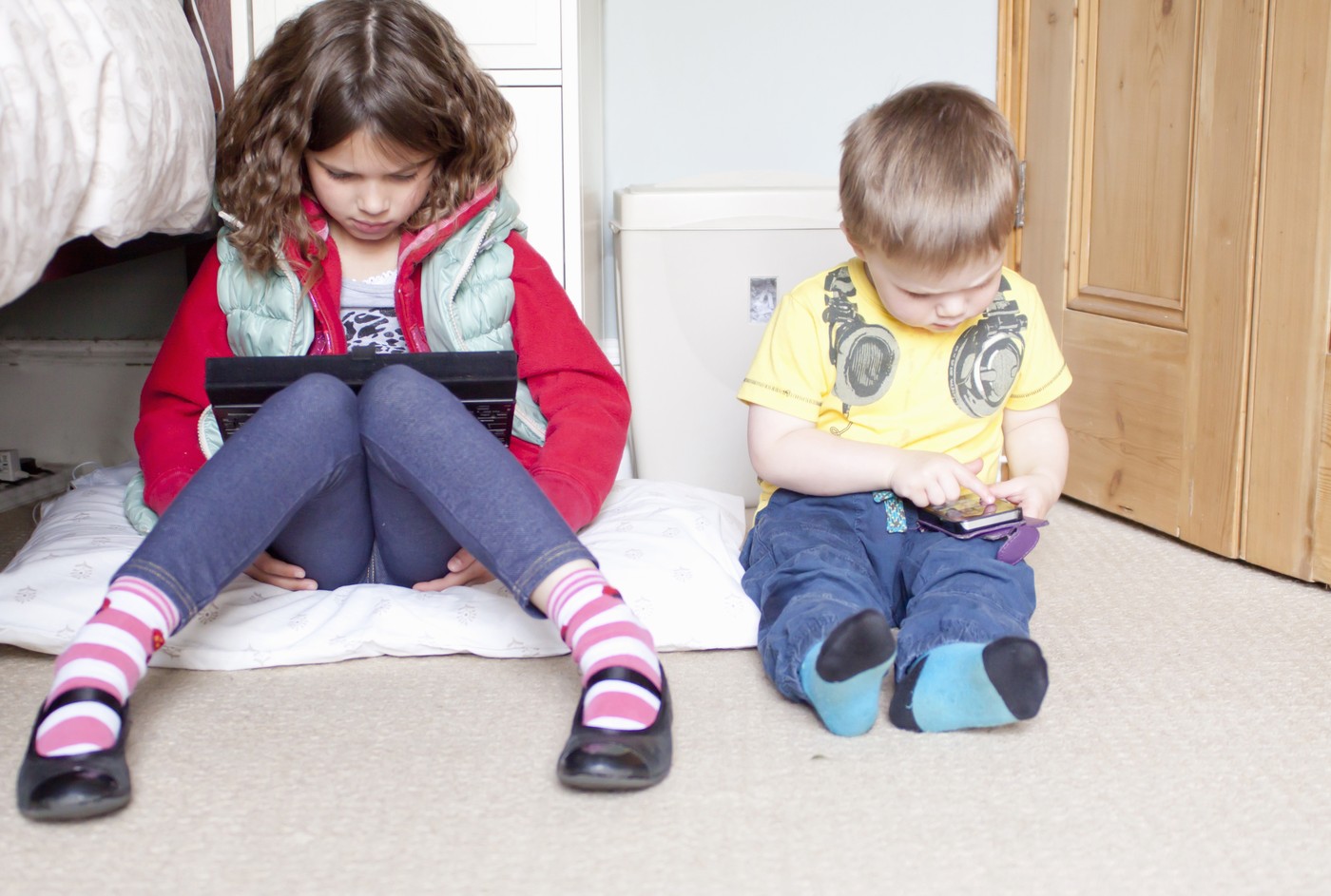 deklica na tablici deček na mobilnem telefonu