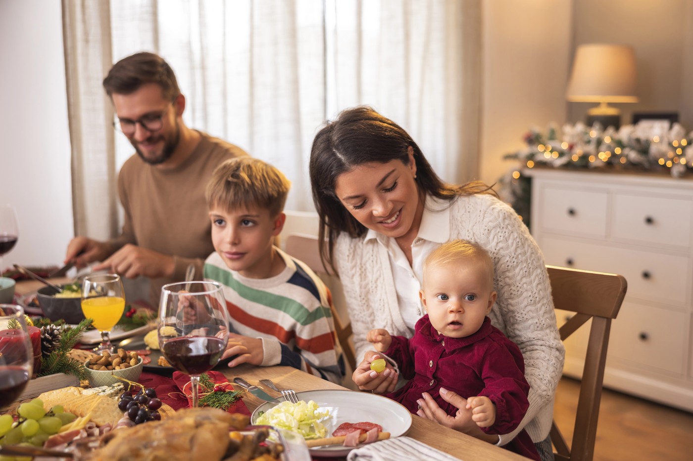 družina sedi za praznično mizo mama oče otroka