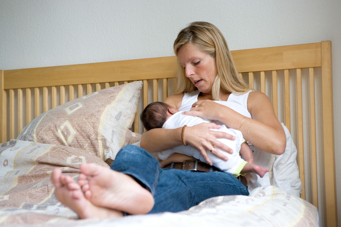 mama na postelji doji otroka