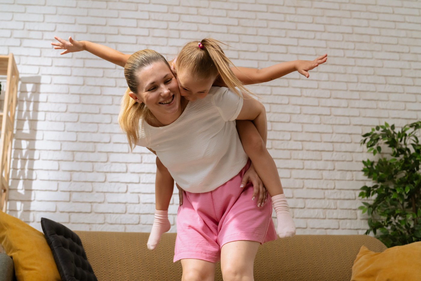 nasmejani mama in hči, mama nosi hčerko na hrbtu