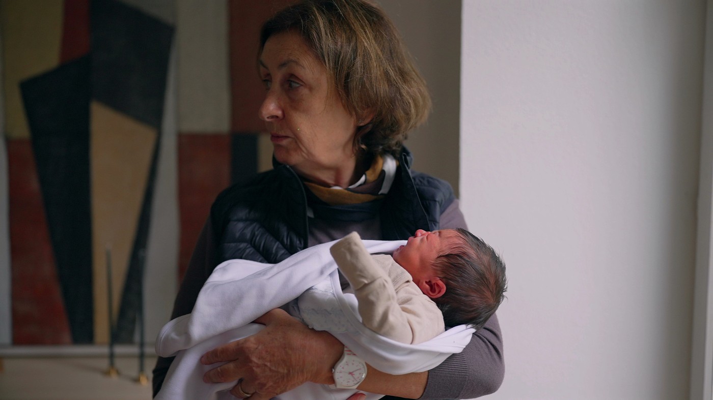 babica v naročju drži novorojenčka