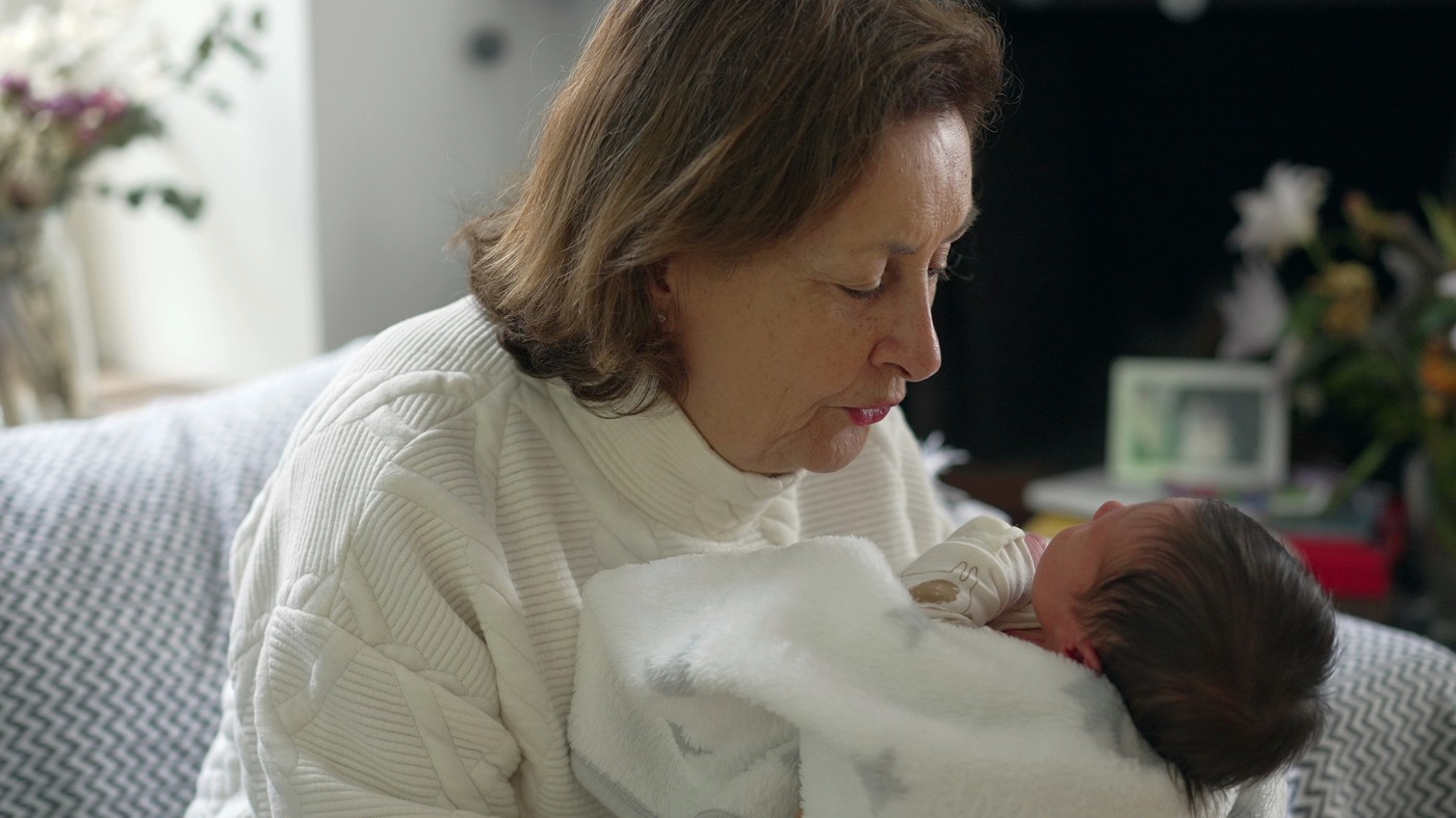babica v naročju drži novorojenčka