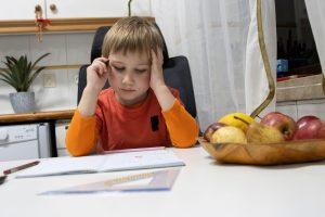 otrok dela domačo nalogo v kuhinji