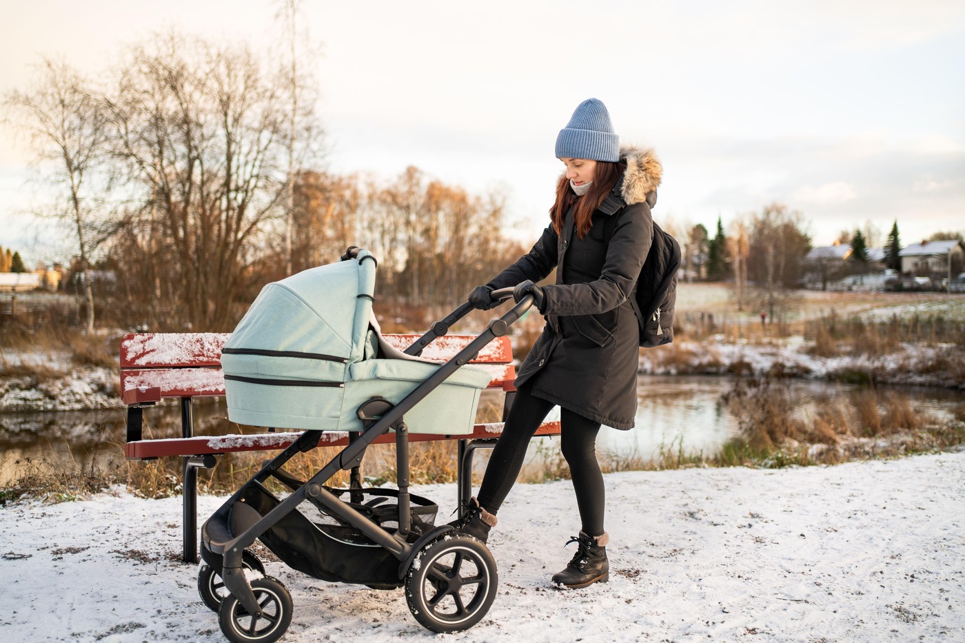 mamica pozimi z vozičkom v parku