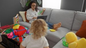 ženska dela na računalniku, medtem ko se otrok igra