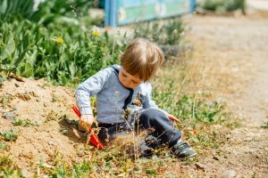 deček se z lopatko igra na prostem na soncu