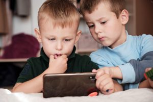 dečka gledata risanke na telefonu