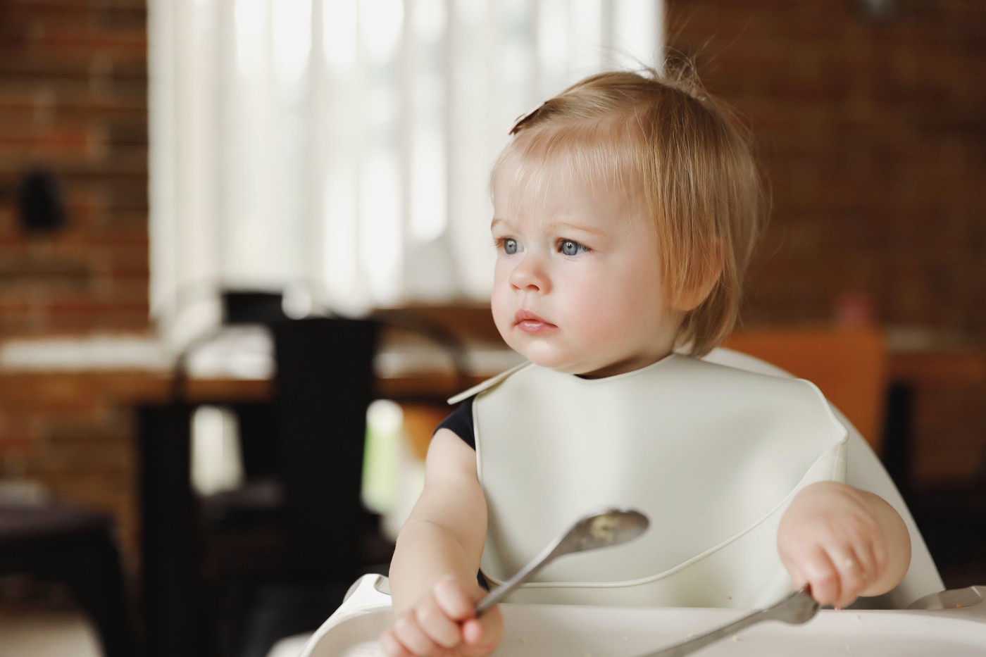 dojenčica sedi v stolčku za hranjenje