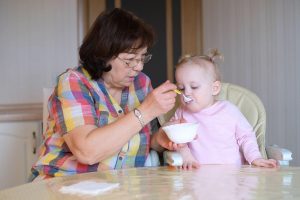 babica hrani vnukinjo z žlico