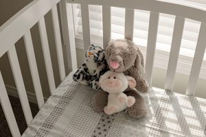 tri plišaste igrače v prazni posteljici