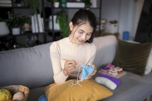 deklica sedi na kavču in kvačka