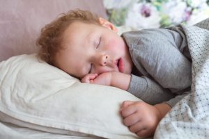 malček spi v postelji