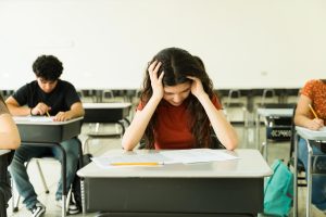 učenci v učilnici sedijo za mizami in pišejo test