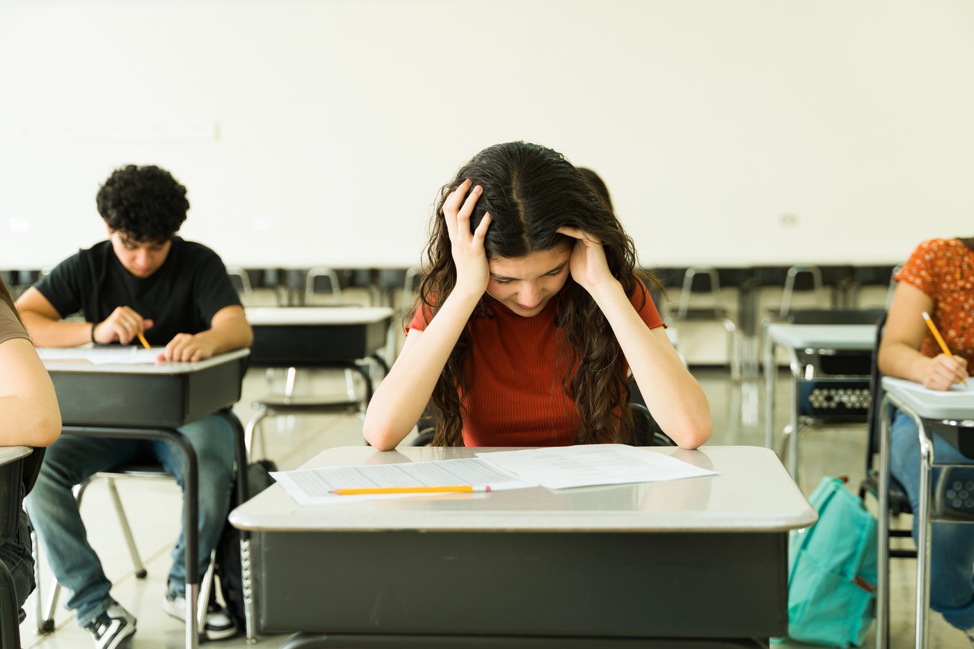 učenci v učilnici sedijo za mizami in pišejo test