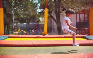 deklica v parku skačne na trampolinu