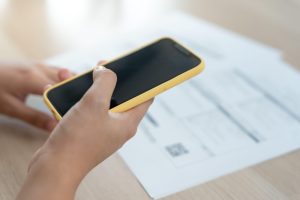 oseba drži v rokah telefon in skenira qr kodo