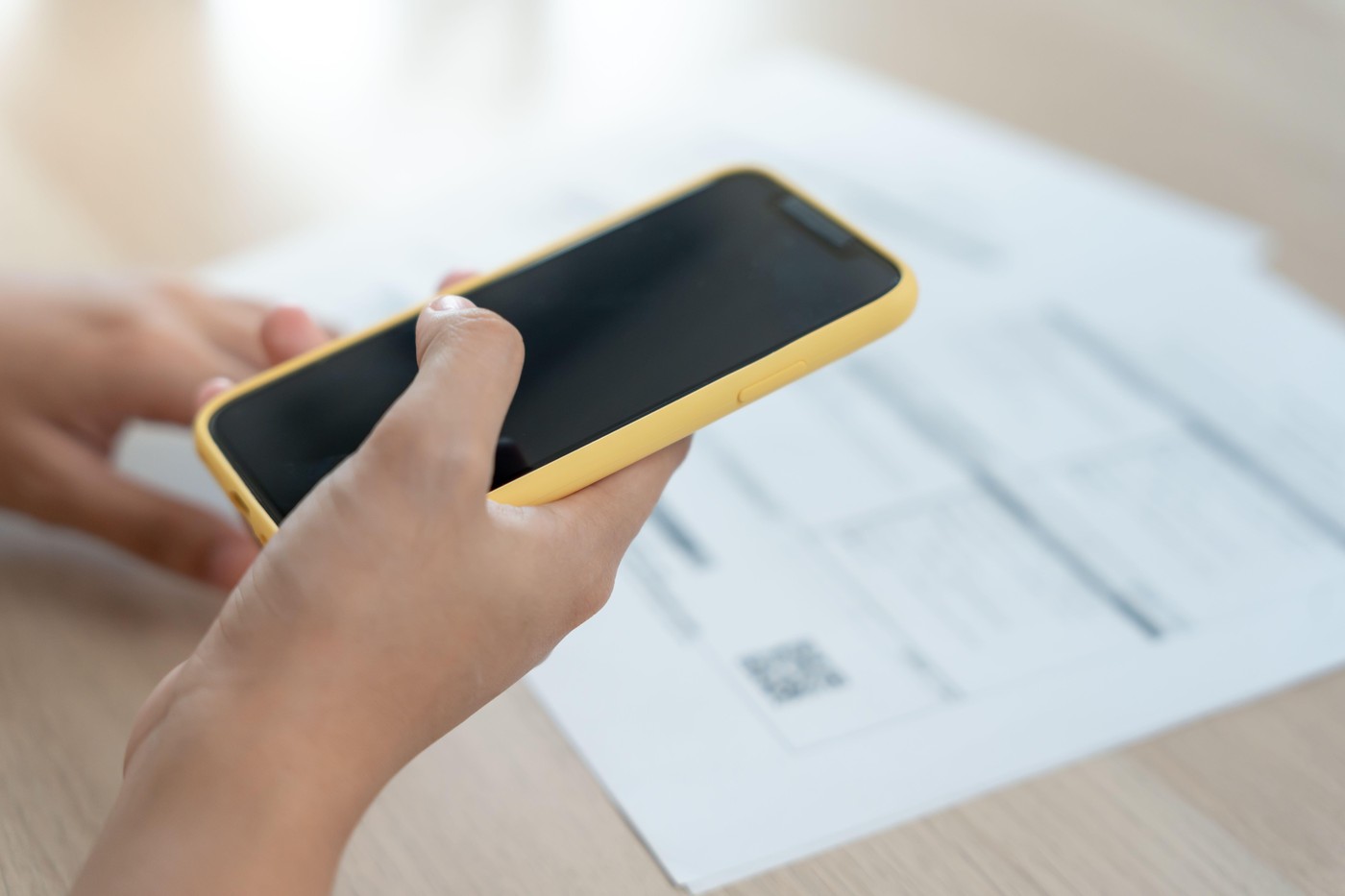 oseba drži v rokah telefon in skenira qr kodo