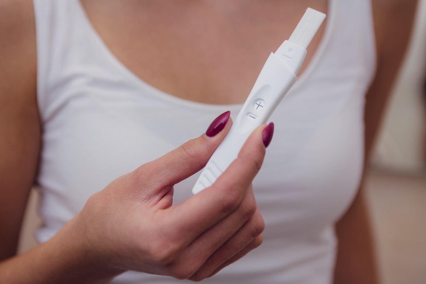 ženska drži nosečniški test v rokah
